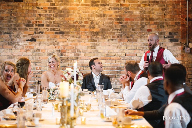 Groomsman laughing during wedding toast
