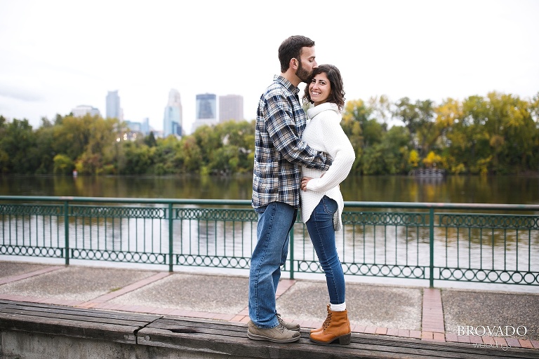 Stephanie and Loren kissing in front of minneapolis skyline