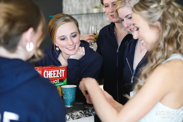 Bridesmaids watching Natalie put on jewelry