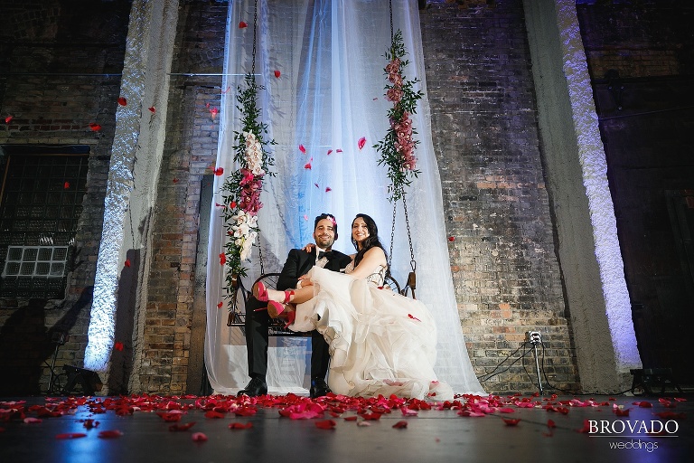 Yevgenia and Eugene sitting on floral swing at aria