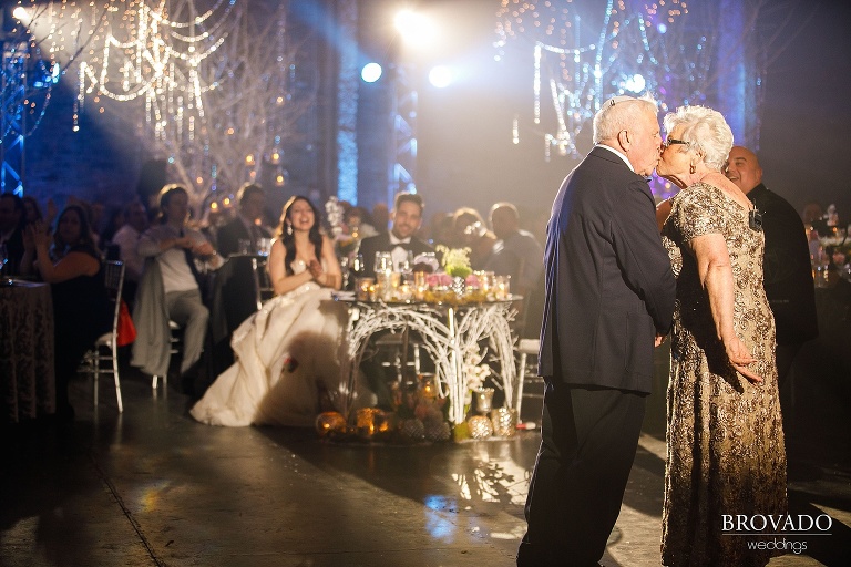 Yevgenia's grandparents kissing in front of wedding reception