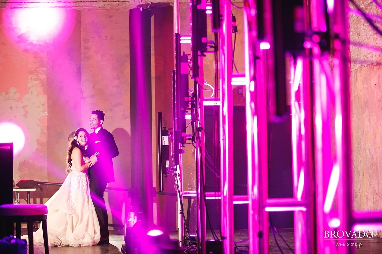 Bride and groom posing in pink spotlight