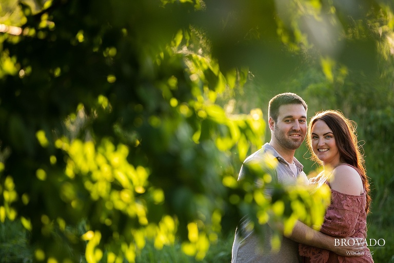 Engaged couple smiling through the trees