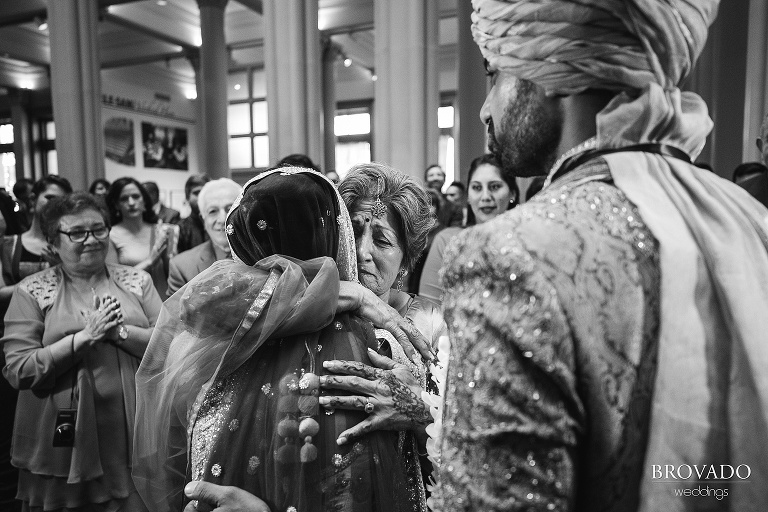 Bride's grandmother hugging her during indian wedding