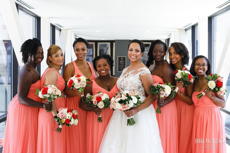 Bride posing with bridesmaids in pink dresses