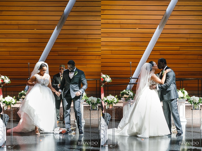 Bride and groom jumping the broom and kissing