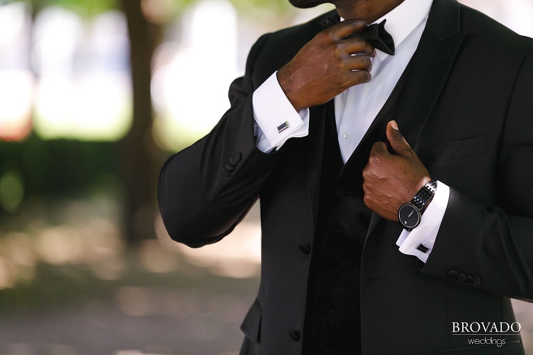 Closeup of groom's watch cufflinks and bowtie