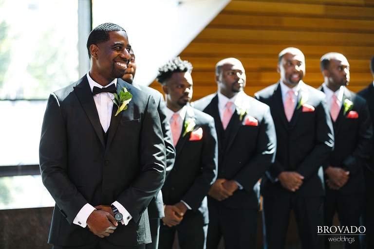 Groom smiling as groomsmen stand behind him