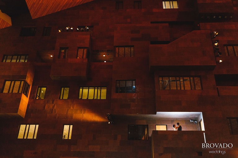 Wide angle of bride and groom on Mcnamara balcony