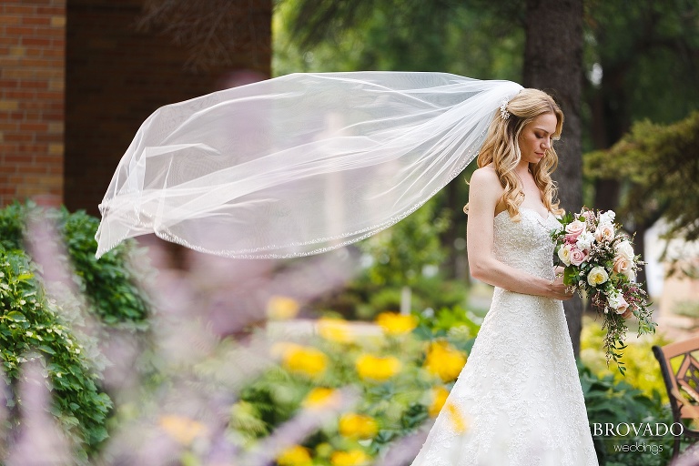 Veil toss while bride looks down at her bouquet