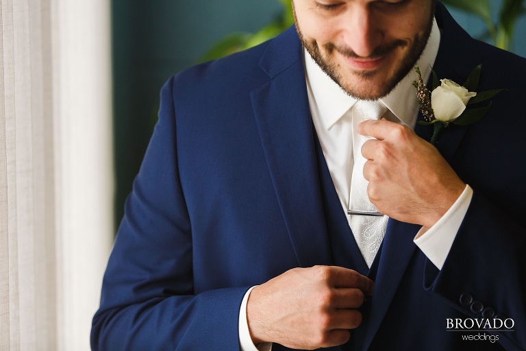 Groom Aaron adjusting his tie