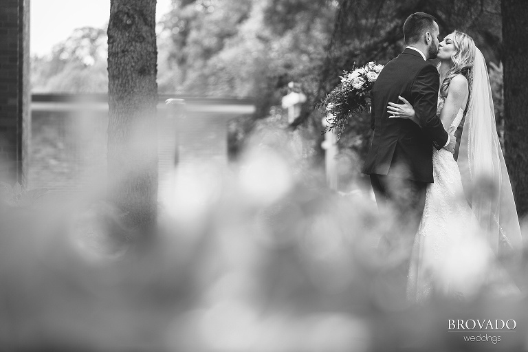 Bride and groom kissing in black and white