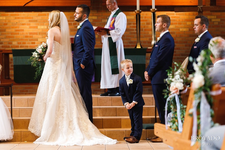 Ring bearer looking around during wedding ceremony