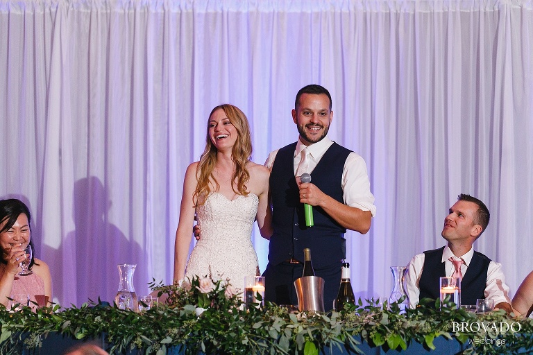 Bride and groom laughing at head table