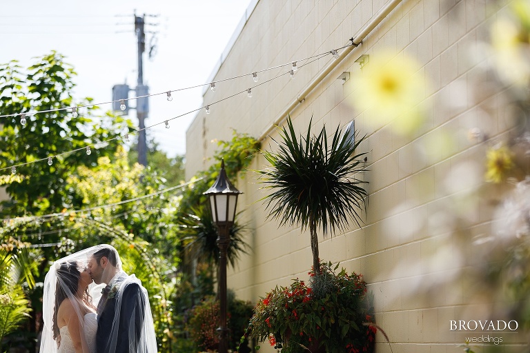 Jacquelyn and Brian kissing underneath veil
