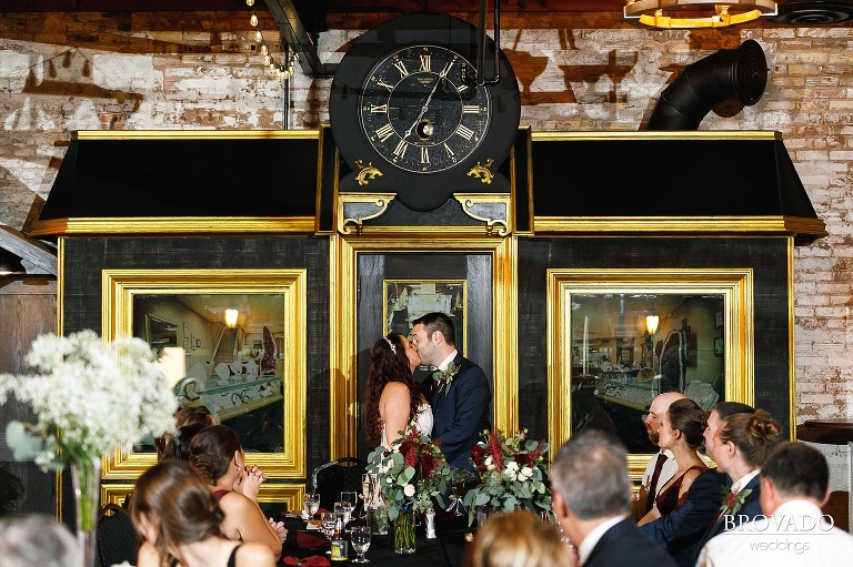 Jacquelyn and Brian kissing in front of wedding reception