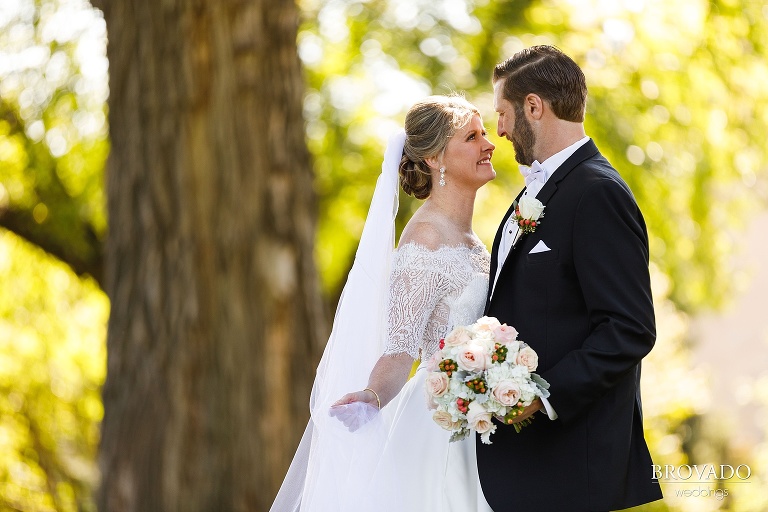 Bride playfully holding her veil in front of the groom