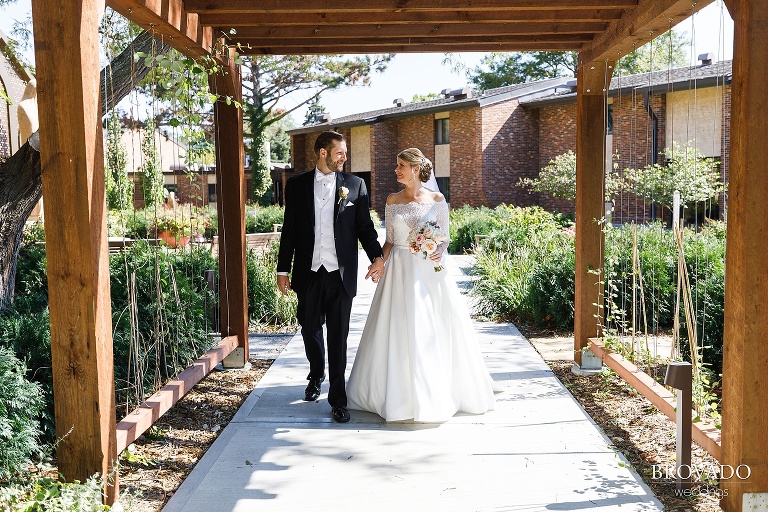 Bride and groom walking under an arch