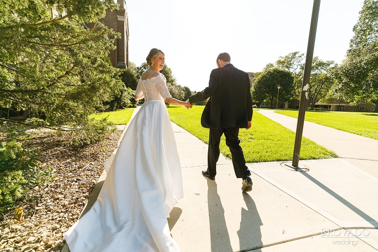 Groom leading bride down the sidewalk