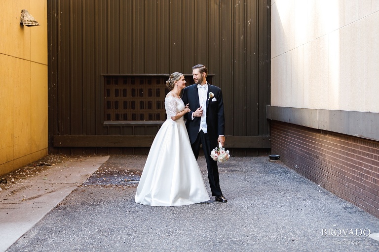 Bride and groom pose in urban setting