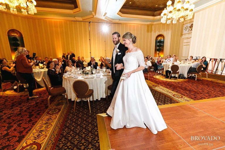 Bride and groom walking into wedding reception