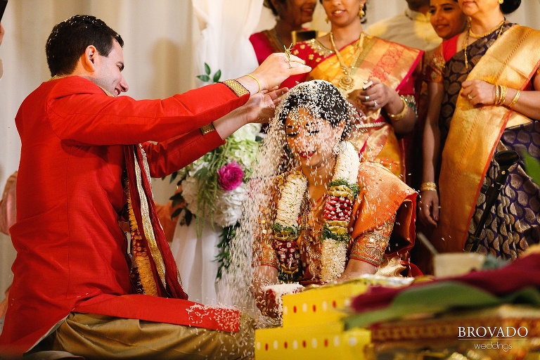 Groom pouring rice over the bride's head