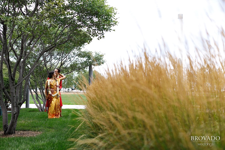 Bride and groom kissing in a field