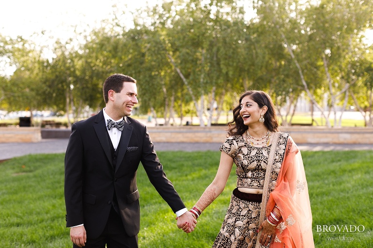 Bride and groom laughing and holding hands