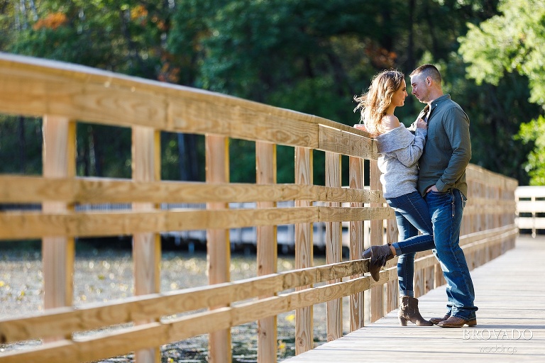 engaged couple Emily and Dan posing on the bridge at Lebanon Hills Park