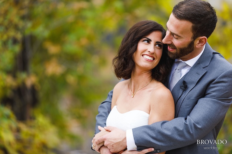 stephanie and loren embracing in front of fall leaves