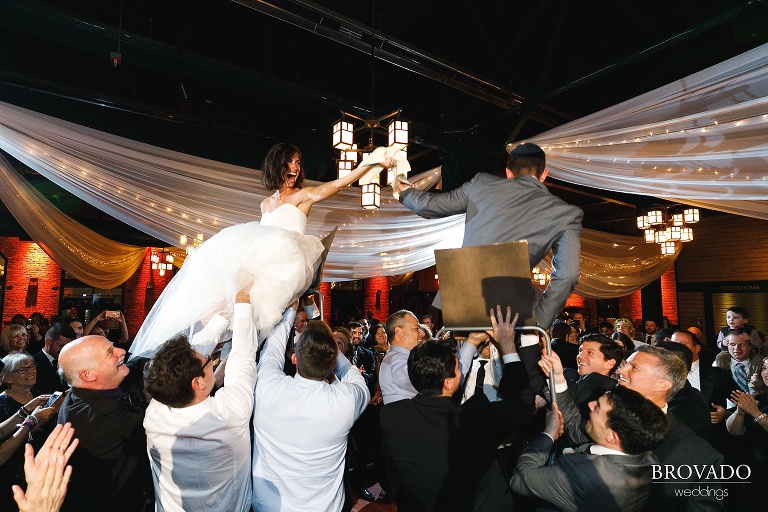 Stephanie and Loren on chairs during Hora