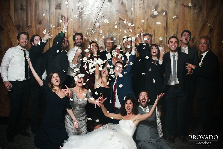 antibooth photo with wedding party throwing petals in the air
