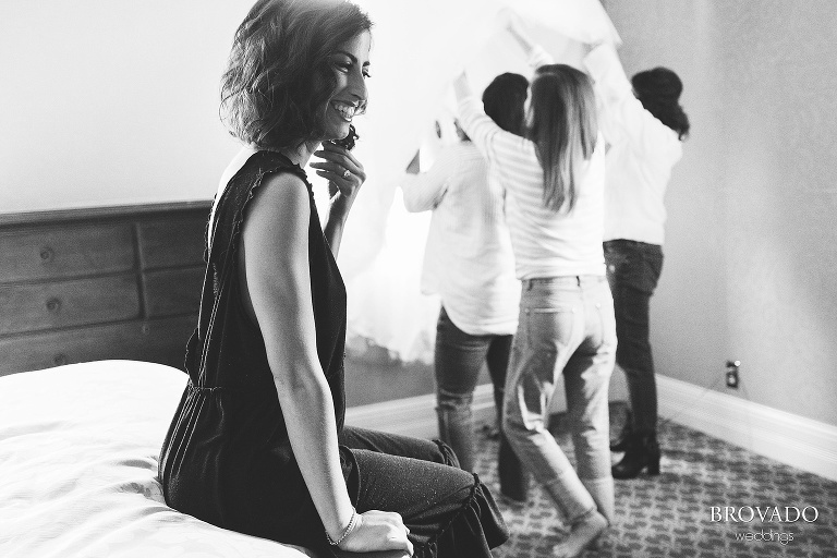 bride Stephanie smiling while her sisters steam her dress