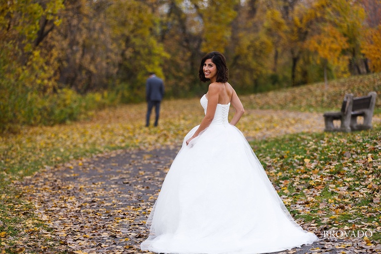 Stephanie smiling over her shoulder with her groom in the background