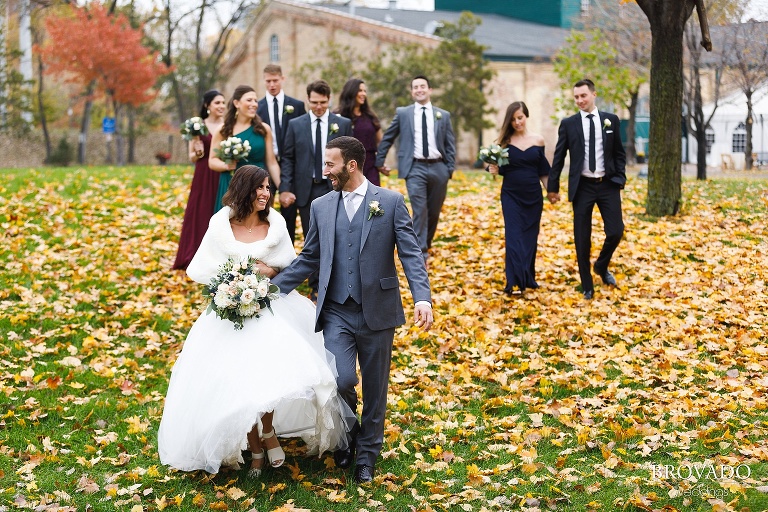 Wedding party walking down a leaf covered hill