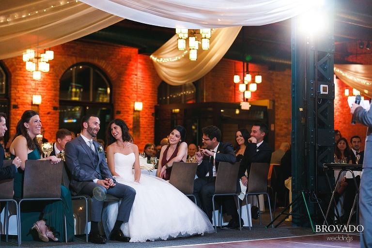 bride and groom laughing during wedding speeches