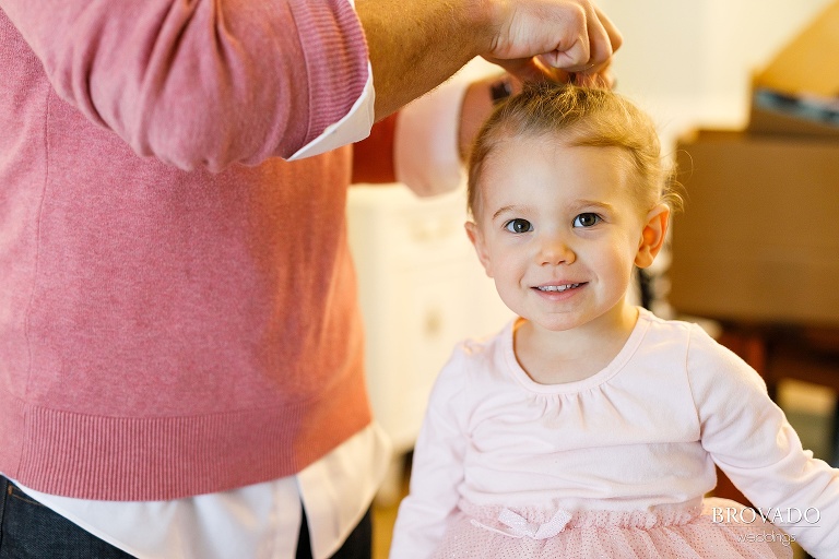 father putting his daughter's hair in a ponytail