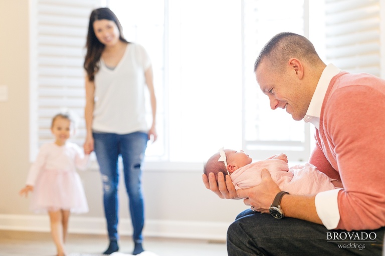 Tyler holding his newborn daughter with his family in the background