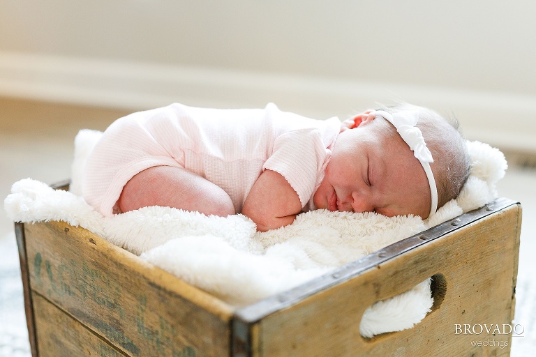 close-up newborn photo of baby girl sleeping in a crate