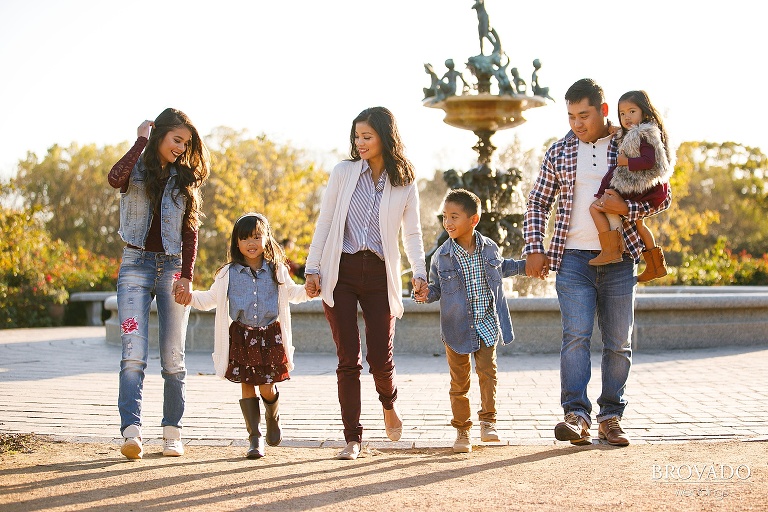 Family in coordinating maroon and denim walking towards the camera