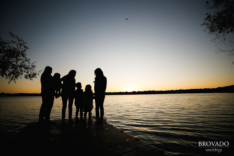 Silhouette of family on the lake with a plane flying overhead