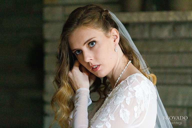 Dramatic shot of bride putting on her earrings