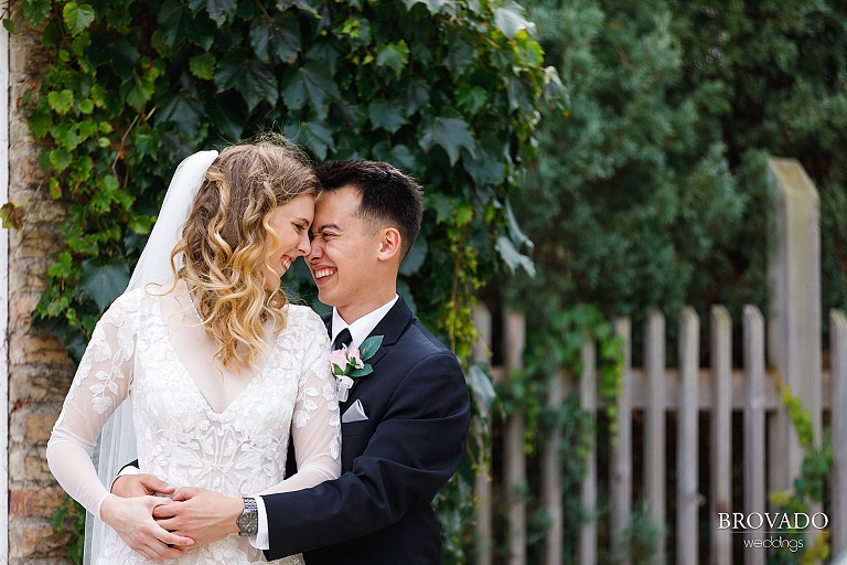 Bride and groom laughing with noses together