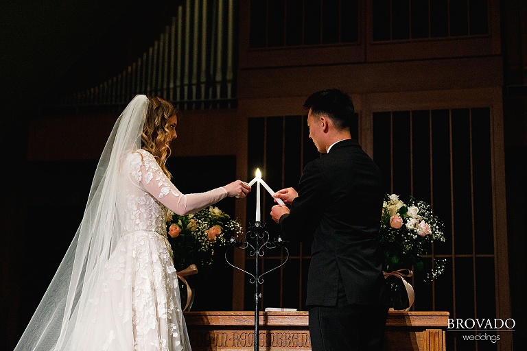 Bride and groom lighting a candle during ceremony