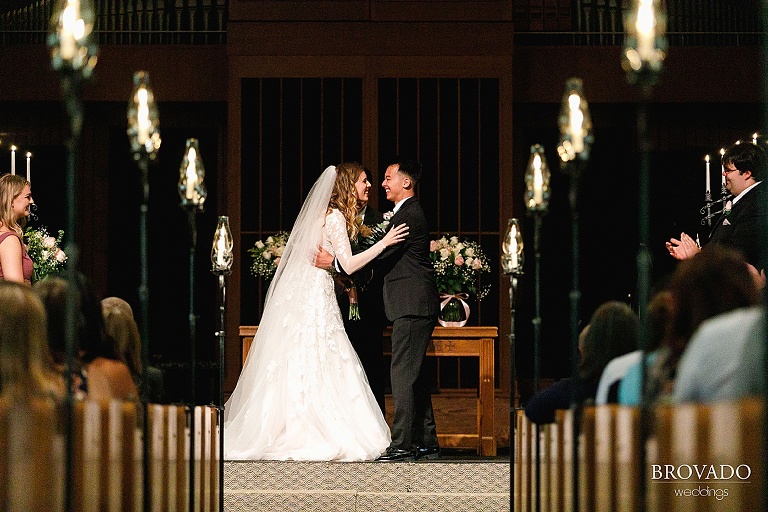 Newlyweds laughing at the altar