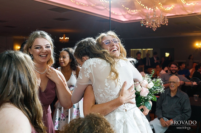 Sarah hugging the bridesmaid that caught the bouquet