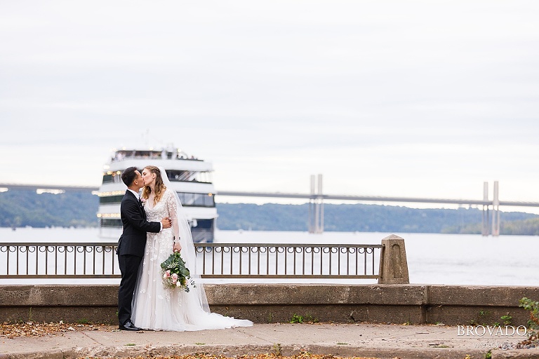 Bride and groom kissing in front of riverboat on the st croix in Stillwater