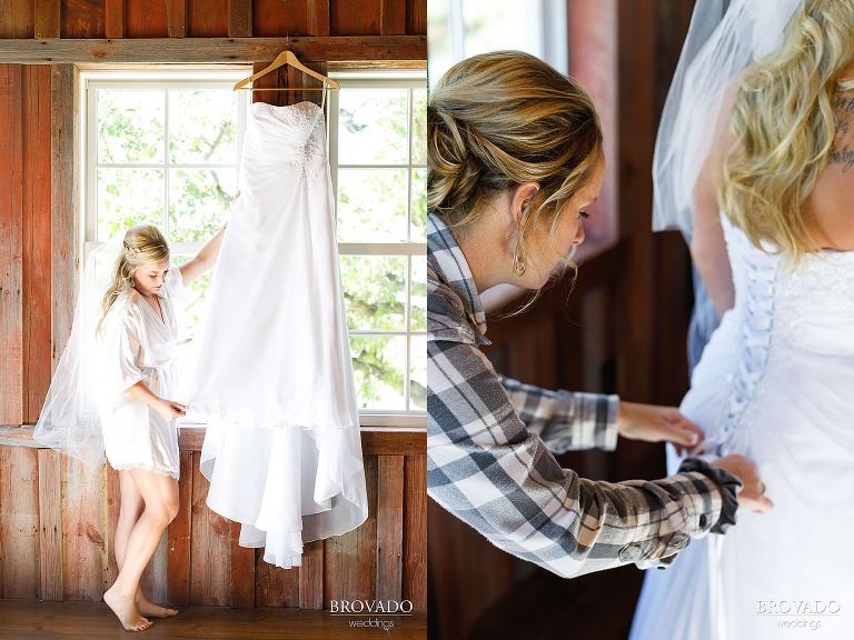 Bride putting on her dress in farm wedding location