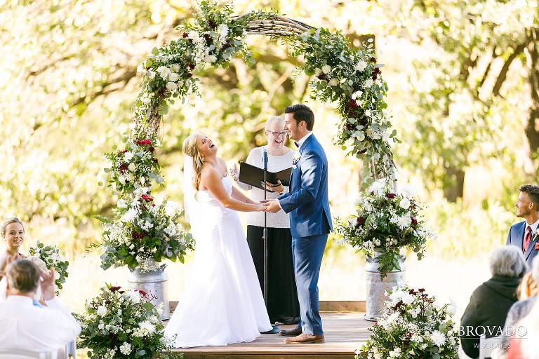 Bride and groom laughing during bright ceremony