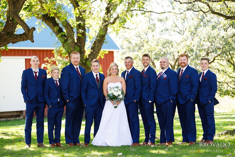 Bride standing between smiling groomsmen
